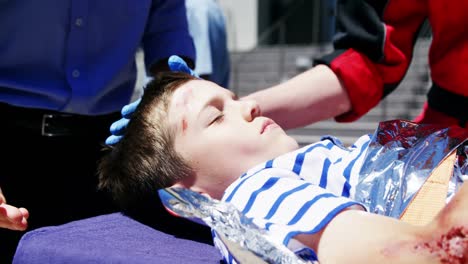 paramedics examining injured boy