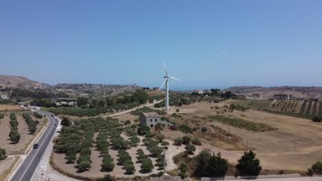 aerial view: wind turbine on mediterranean farm hilltop, europe