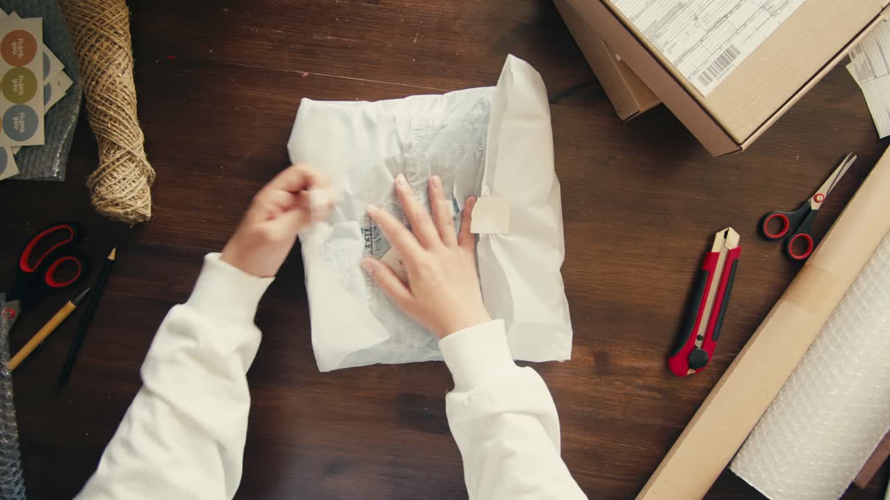 E-commerce storage shop, woman packing goods and clothes for second hand delivery market, dedicated Packaging and Shipping Workspace with Supplies and Technology for efficiency, online sales.