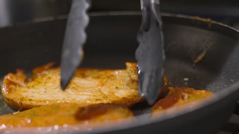 raw chinese chicken steak fillets being turned in over in hot pan to cook on boths sides. oriental style cuisine. food photography footage 4k.