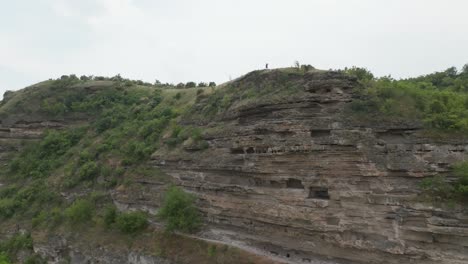 Bergabfliegen,-Darüber-Die-Silhouette-Einer-Person,-Die-Im-Vergleich-Zum-Berg-Sehr-Klein-Ist