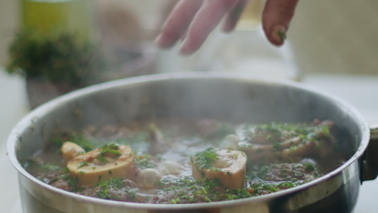 mujer agregando verduras al estofado ossobuco en la sartén