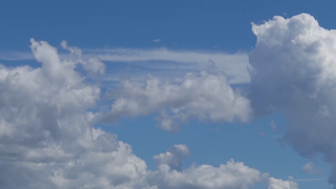 Watch cumulus clouds evolve and shift in a vibrant blue sky, showcasing nature's dynamic beauty.