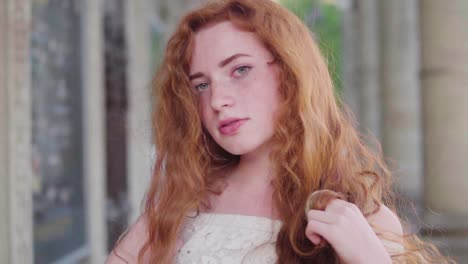 wind blowing red curly hair of the beautiful natural young girl, without make-up in a light dress