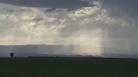 rayos de sol cortando intensas nubes sobre los campos del valle imperial en el sur de california