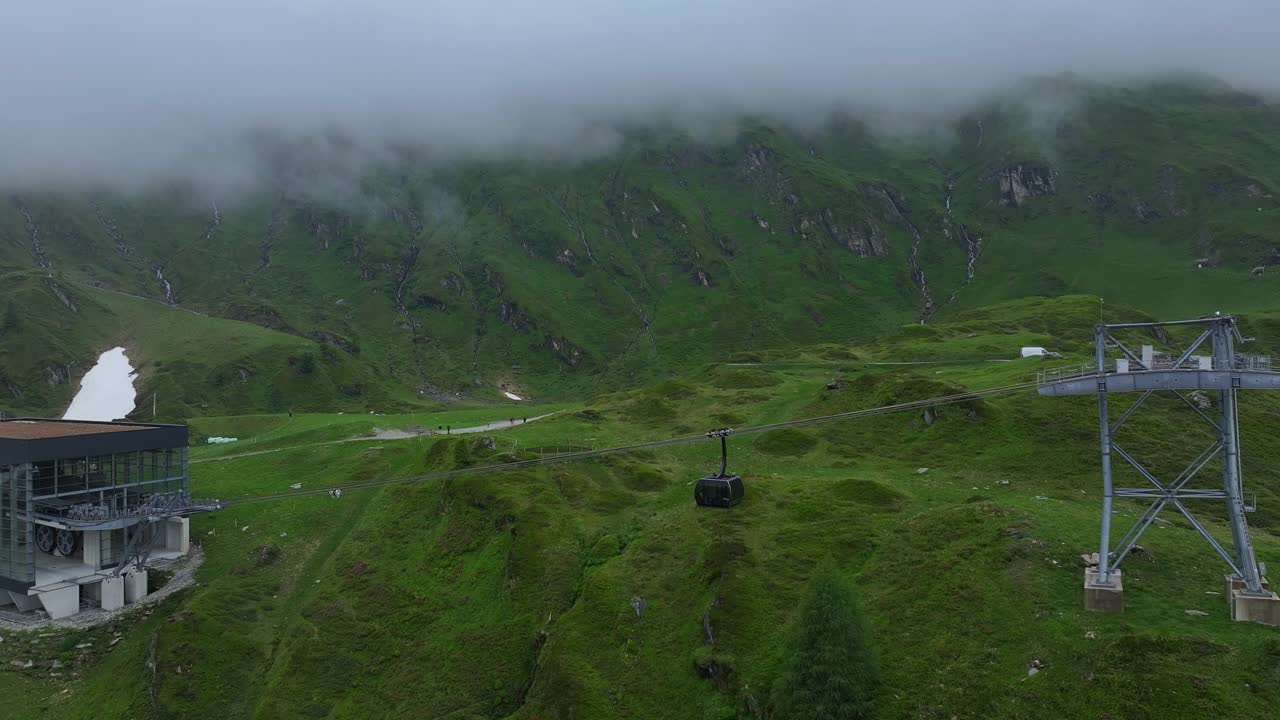 toma de seguimiento del teleférico en la estación de esquí de kitzsteinhorn y el fondo de los alpes cubiertos de niebla.