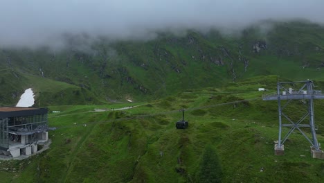 Toma-De-Seguimiento-Del-Teleférico-En-La-Estación-De-Esquí-De-Kitzsteinhorn-Y-El-Fondo-De-Los-Alpes-Cubiertos-De-Niebla.