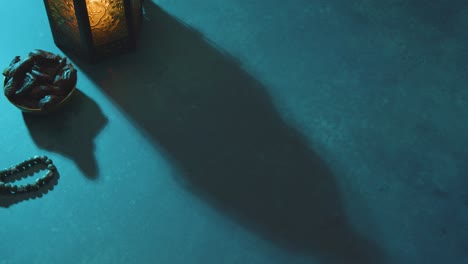 high angle tracking shot of dates water beads and lantern on table