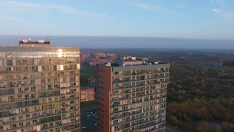 an aerial view of a modern, newly built house with a glass facade that reflects the evening sun