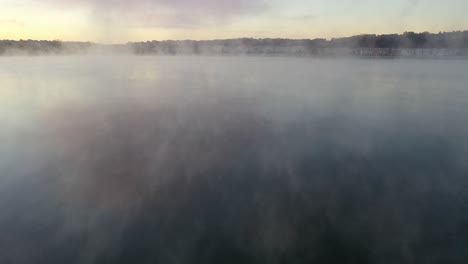 misty sunrise over a lake with residential area