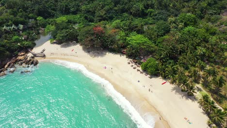 foamy-waves-washing-the-white-sand-shore-of-Koh-Pha-Ngan-island,-Thailand