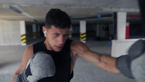 el hombre ejecuta fuertes golpes en el saco de boxeo, acelerar la velocidad de las imágenes
