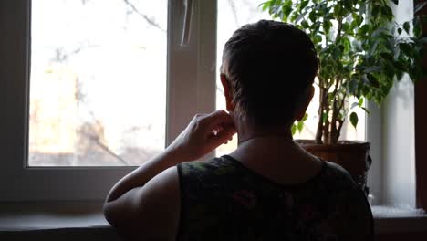 mujer mirando por la ventana