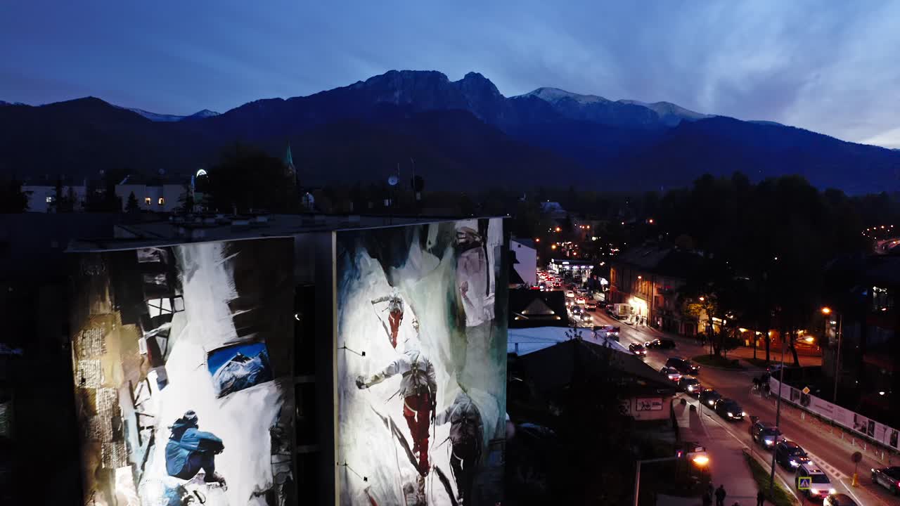 ciudad de montaña al anochecer con murales