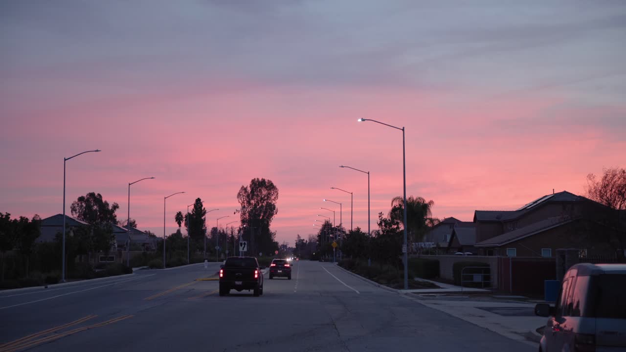 Premium stock video A pastel sky over cars driving away on a road in