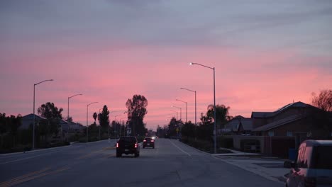 A-pastel-sky-over-cars-driving-away-on-a-road-in-Clovis,-CA,-USA