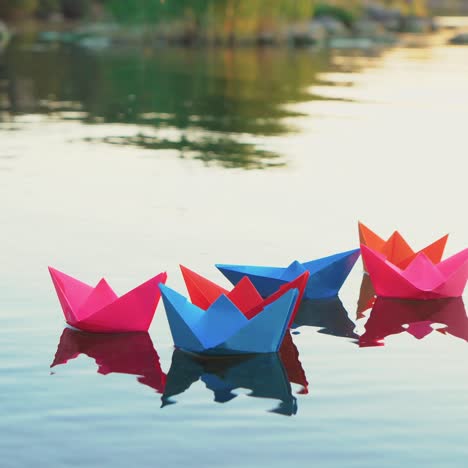 papierboten op het water, gekleurde papieren schepen in het water.