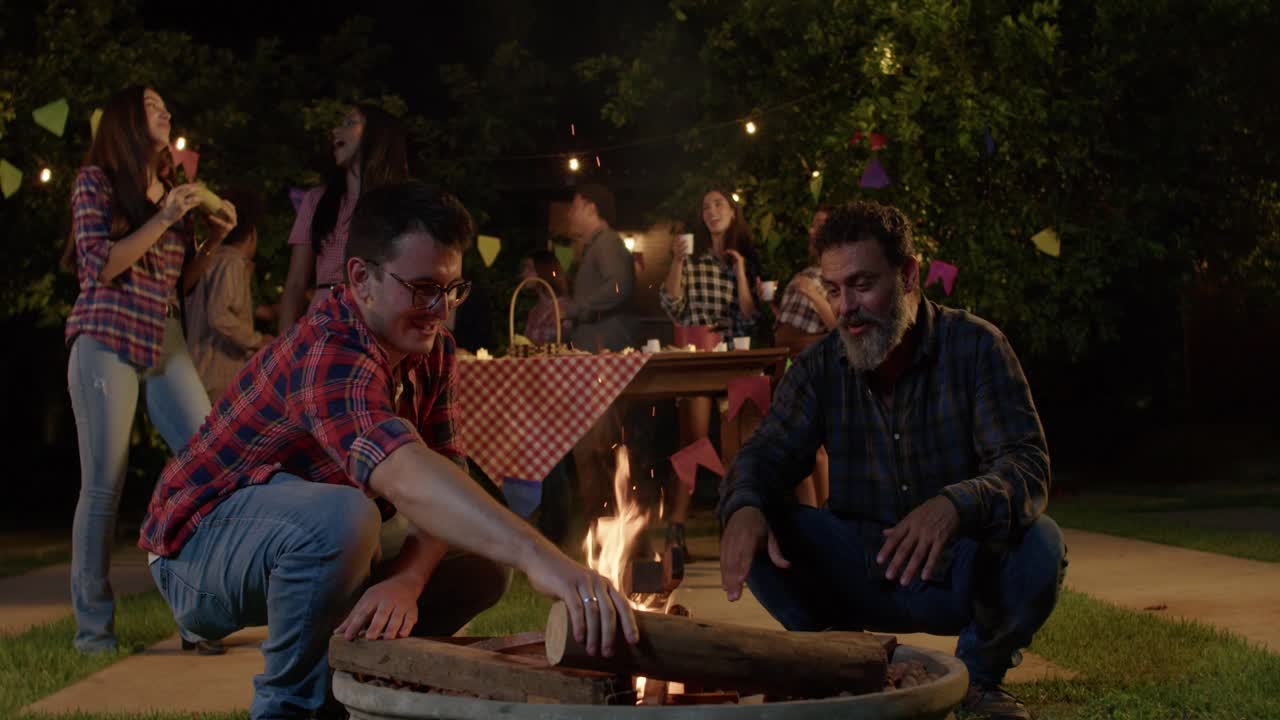 People gathering around a bonfire at a festive outdoor party