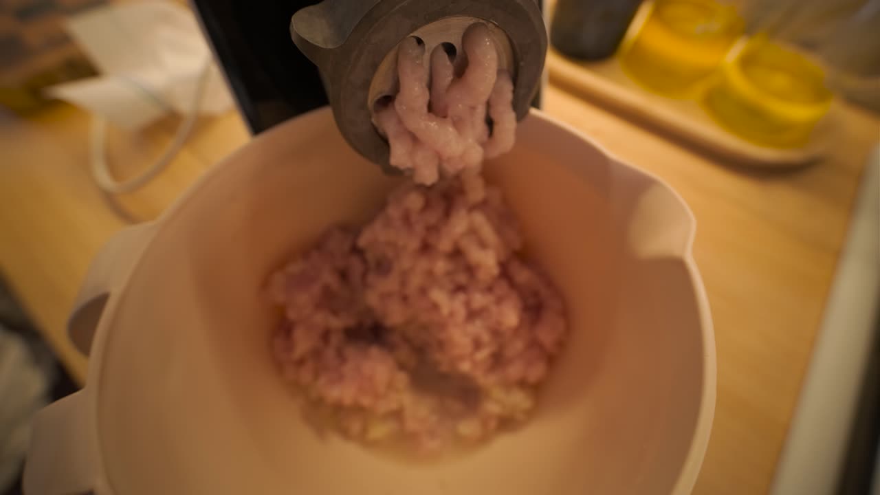 Close-up of Meat Grinder Mincing Raw Meat into a Bowl