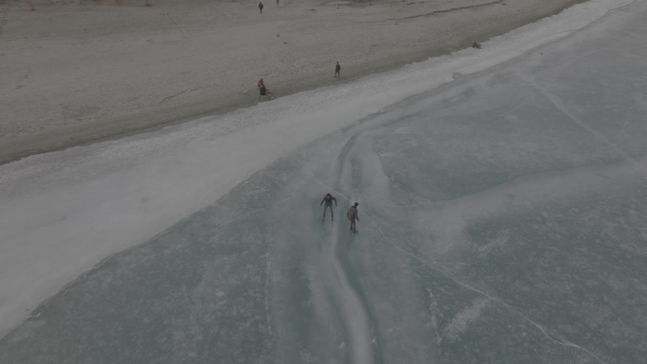 mucha gente sale al lago congelado a patinar sobre hielo