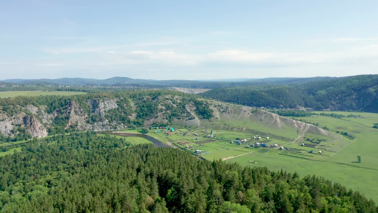 un pequeño pueblo se encuentra a lo largo de una cordillera, con vistas desde arriba. espeso bosque verde y aire fresco. vida rural, un viaje a las montañas con fines de bienestar.