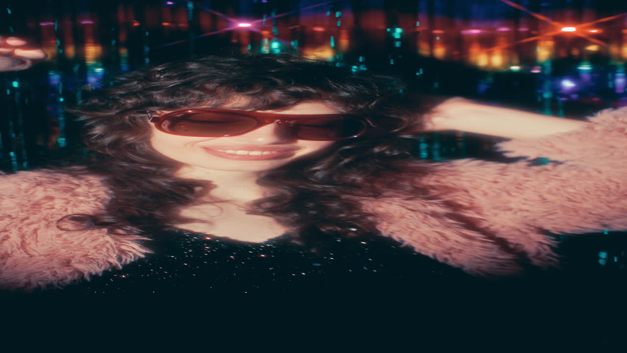 Beautiful Woman in Stylish Outfit Dancing against Shimmering Fringe Curtain