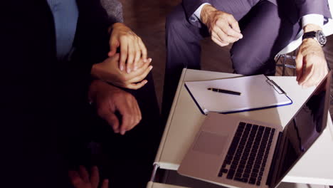 Serious-business-people-working-together-while-looking-laptop