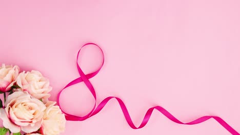 el texto del feliz día de la mujer aparece con cintas y flores.