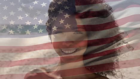 animation of flag of america over portrait of smiling african american young woman at beach