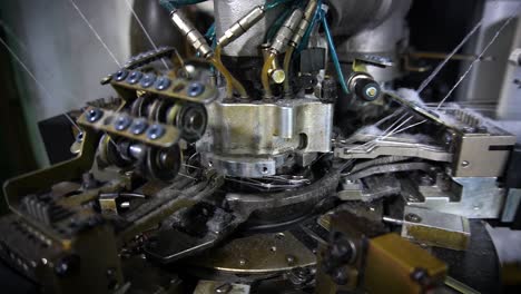 The-process-of-manufacturing-of-socks-on-a-loom---Close-up-shot-of-Spools-with-white-thread-at-rewinding-machine-video