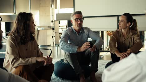 Un-Hombre-De-Mediana-Edad,-De-Pelo-Gris,-Con-Gafas-Y-Traje-De-Negocios,-Habla-De-Su-Experiencia-En-Terapia-De-Grupo-En-La-Oficina