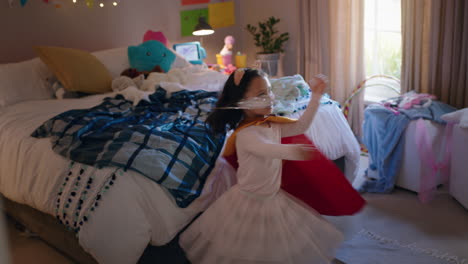 happy little girl dancing wearing costume playing game enjoying playful imagination in colorful bedroom at home