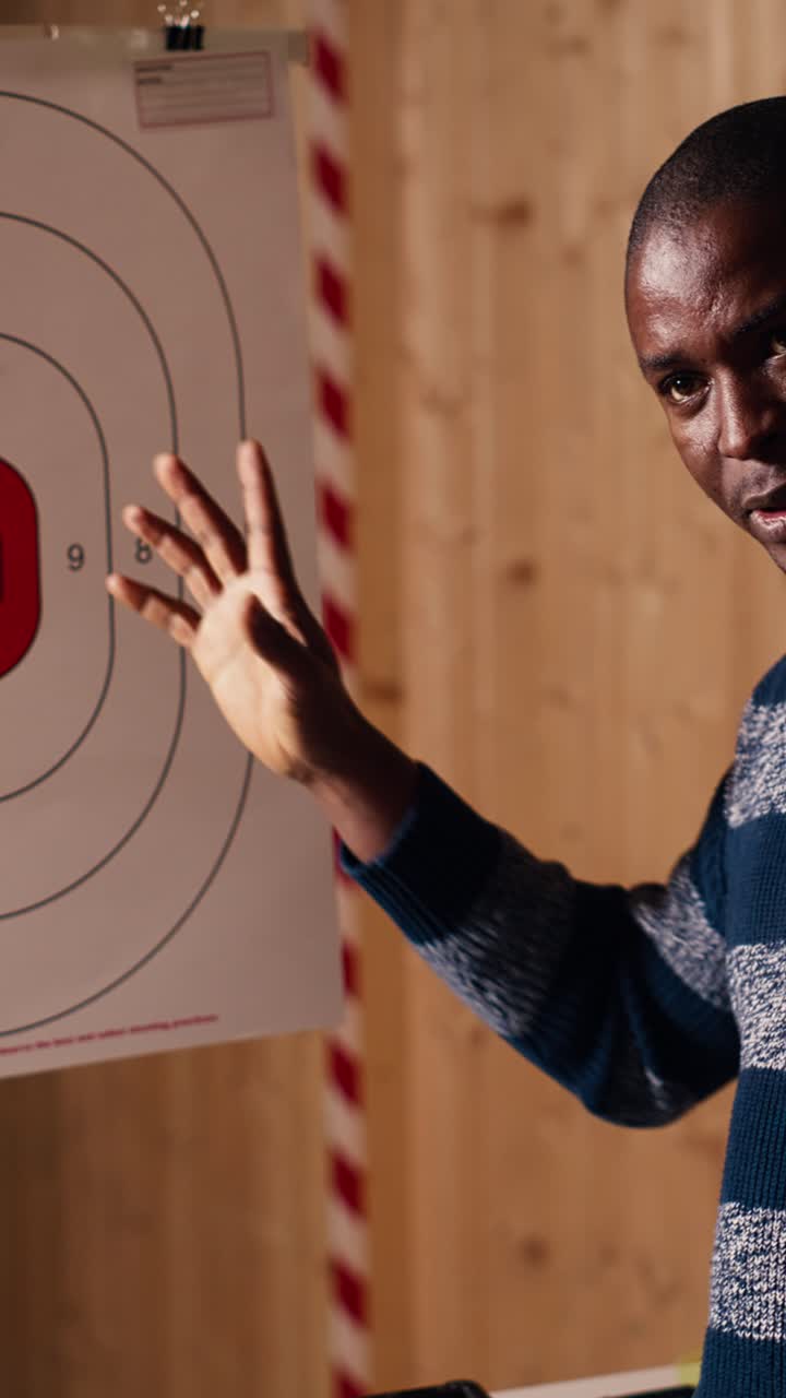 Vertical video Shooting range safety officer explaining bullseye scoring system to people