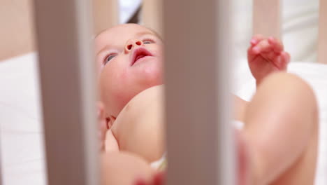 baby in diaper lying in his crib