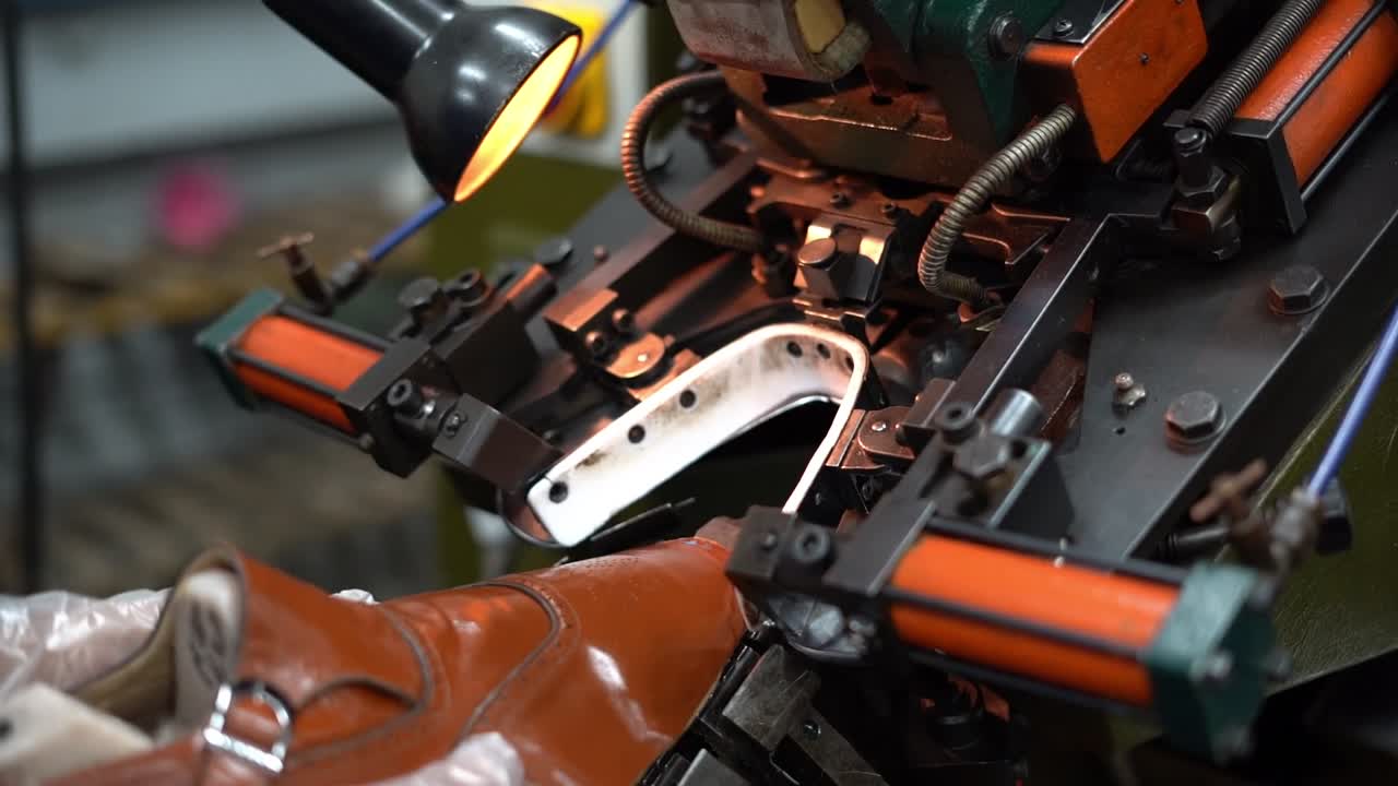 a craftsman handmade a shoe by a machine, close up shot, insert shot