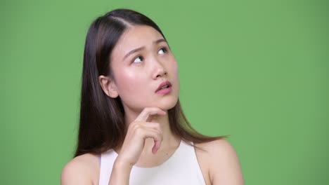 젊은 아름다운 아시아 사업가 여성이 생각하고 있습니다.
