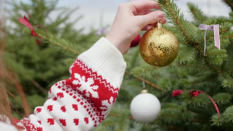 mujer decorando el árbol de navidad afuera