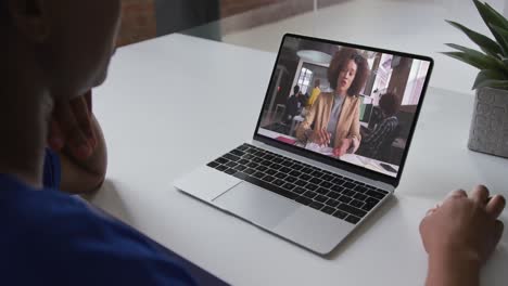 sección media de una mujer afroamericana haciendo una videollamada con una colega en una computadora portátil en la oficina