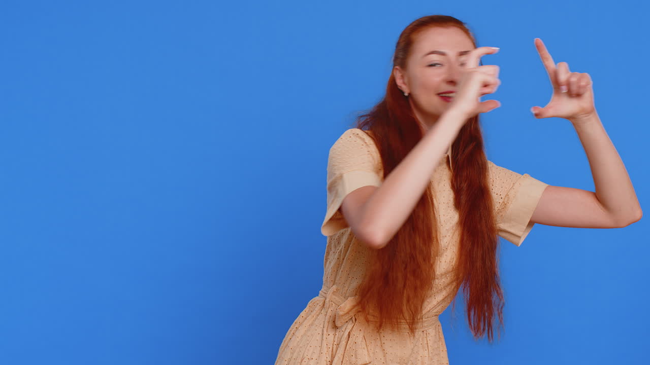 성인 젊은 여성 사진작가는 흥미로운 순간 이미지에 초점을 맞추는 손으로 그림 프레임을 보여줍니다.