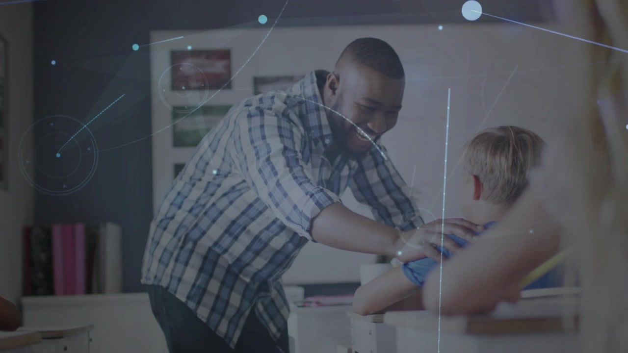 Male teacher entering classroom, leaning over desk and guiding student with network lines