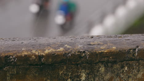 Close-up-rain-falls-on-stone-balcony-surface