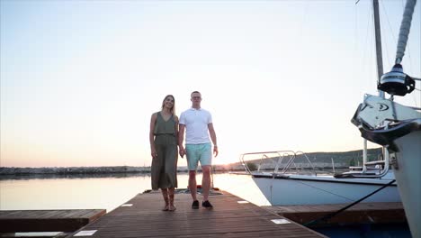 couple walking on a pier at sunset