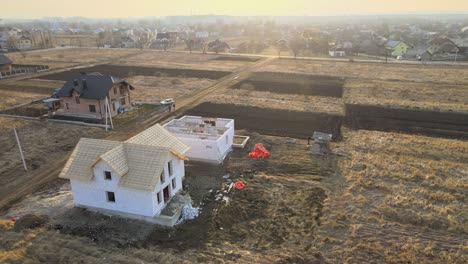 aerial view of unfinished frame of private house with aerated lightweight concrete walls and wooden roof frame under construction
