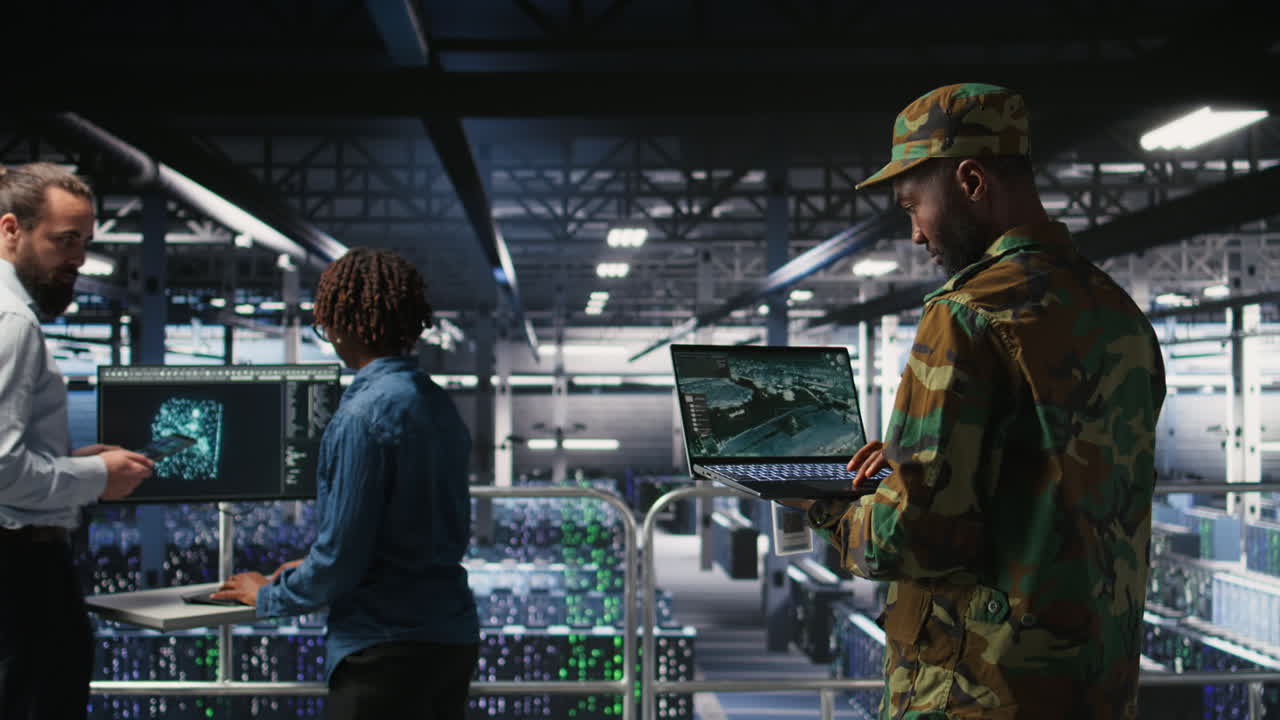 Military technician in data center monitoring warfare drone telemetry on laptop