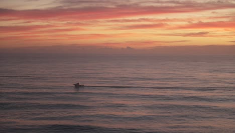 boat at sunset on calm ocean