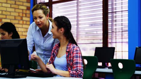 Teacher-assisting-students-in-computer-class