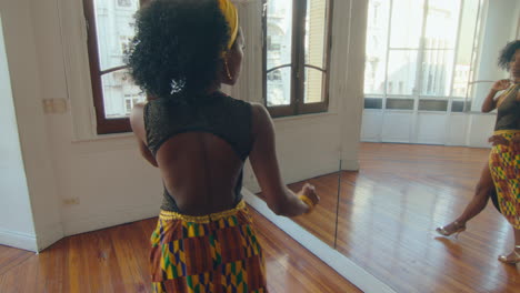beautiful black woman practicing tango steps in a dance studio