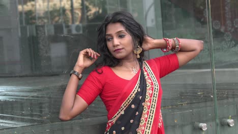 hermosa mujer modelo de etnia india asiática con un saree rojo posando para una sesión de fotografía.