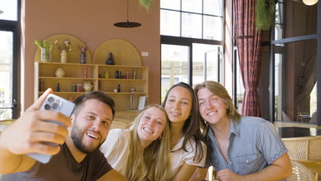 Group-Of-Friends-Taking-A-Selfie-Photo-And-Having-Fun-While-Eating-Pizza-In-A-Restaurant