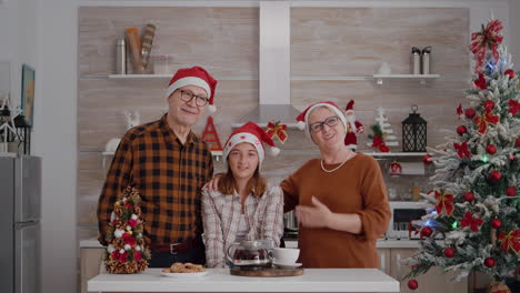 pov of family wearing santa hats greeting friends during online videcall meeting conference